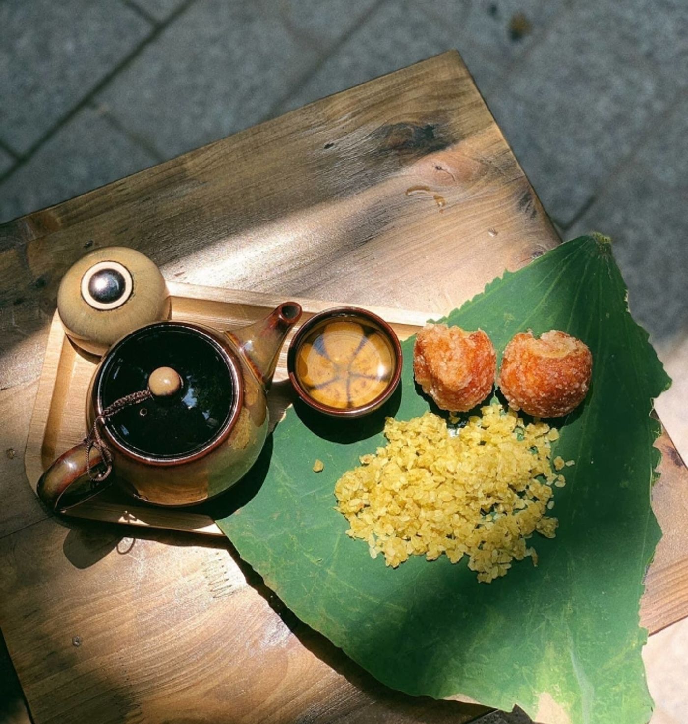 Young green rice is placed on a piece of lotus leave, together with fried rice cakes and tea at a shop in Hanoi. Photo by VnExpress/Thao Nhi